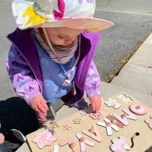 a granddaughter playing with the custom name montessori wooden board