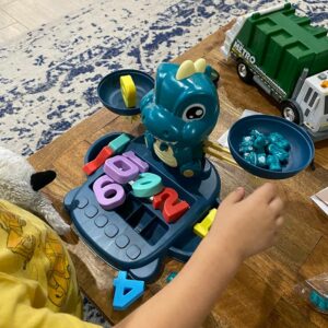 a young boy playing with the educational dinosaur game toy