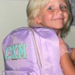 a young girl wearing the make it yours backpack bundle