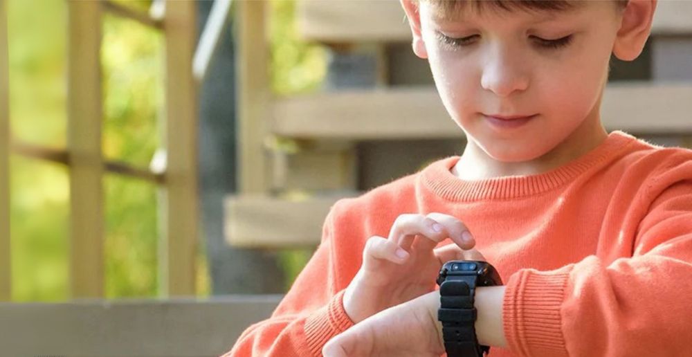 Child wearing a colorful multi-purpose smartwatch while playing outdoors